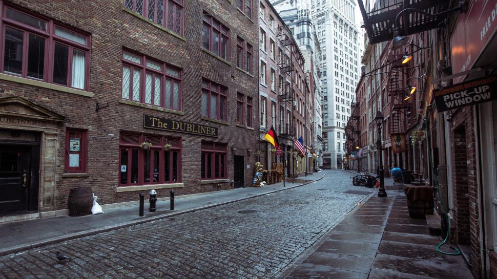 Free Image of Cobblestone street with historic architecture and flags 