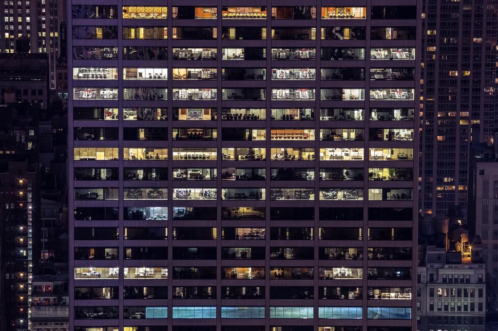 Free Image of Office building with illuminated windows visible at night 