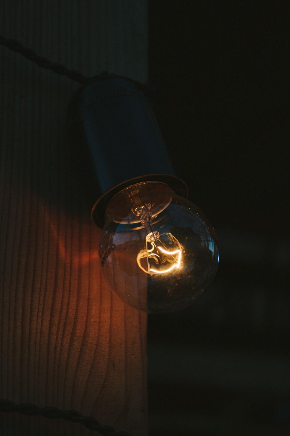 Free Image of Close-up of a glowing lightbulb against a dark background 