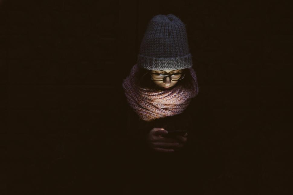 Free Image of Person bundled in winter clothes using a mobile phone 