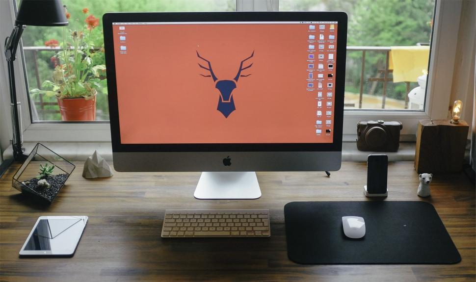 Free Image of Modern workstation with iMac and orange wallpaper 