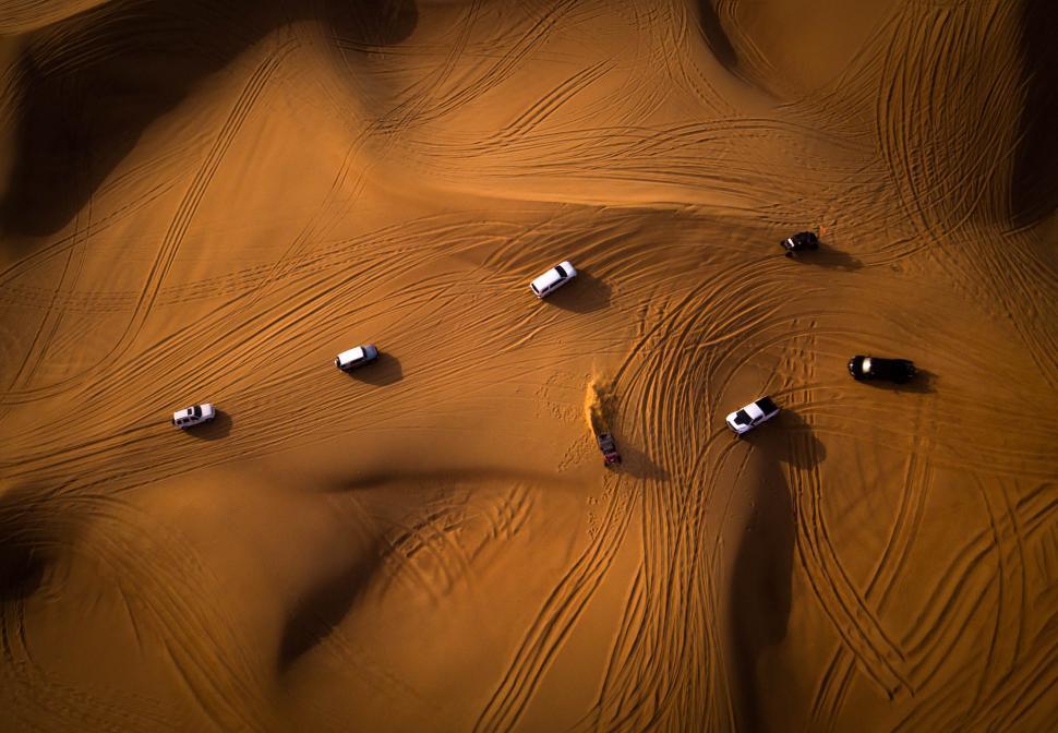 Free Image of Off-roading SUVs create patterns in the desert sand 