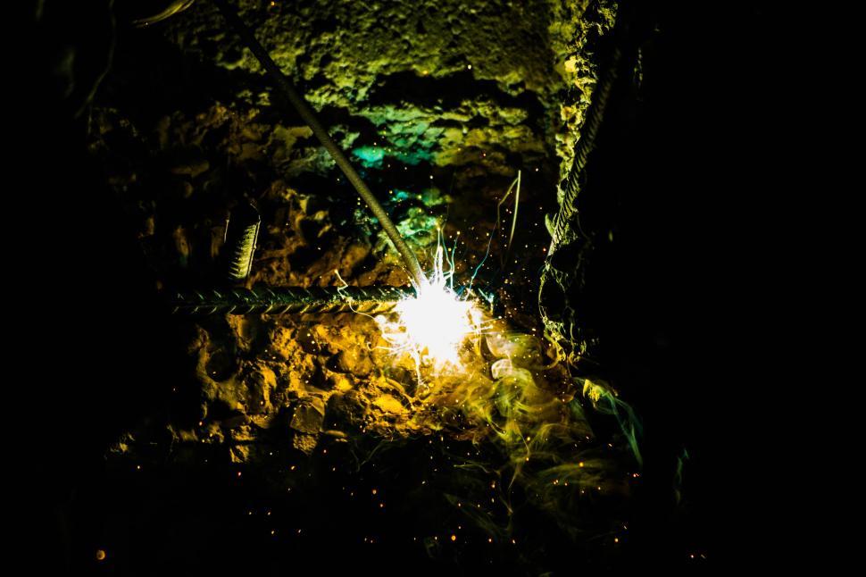 Free Image of Sparks flying during a welding process on metal rods. 