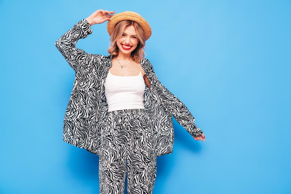 Free Image of Woman in zebra print outfit smiling with hat on. 