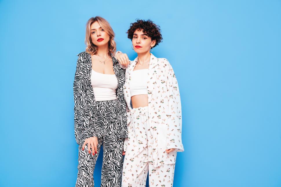 Free Image of Serious women in printed outfits standing together. 