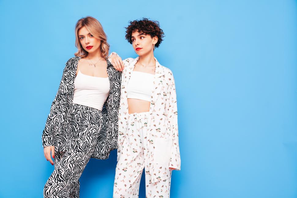 Free Image of Fashionable women posing in printed outfits together. 