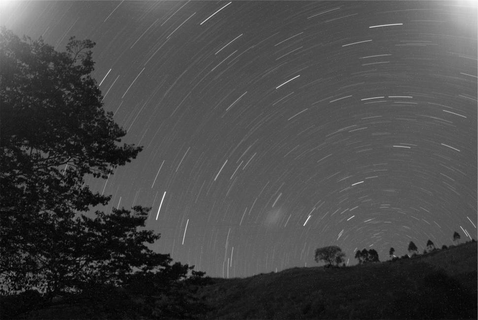 Free Image of Star trails light up the night sky in serene landscape. 