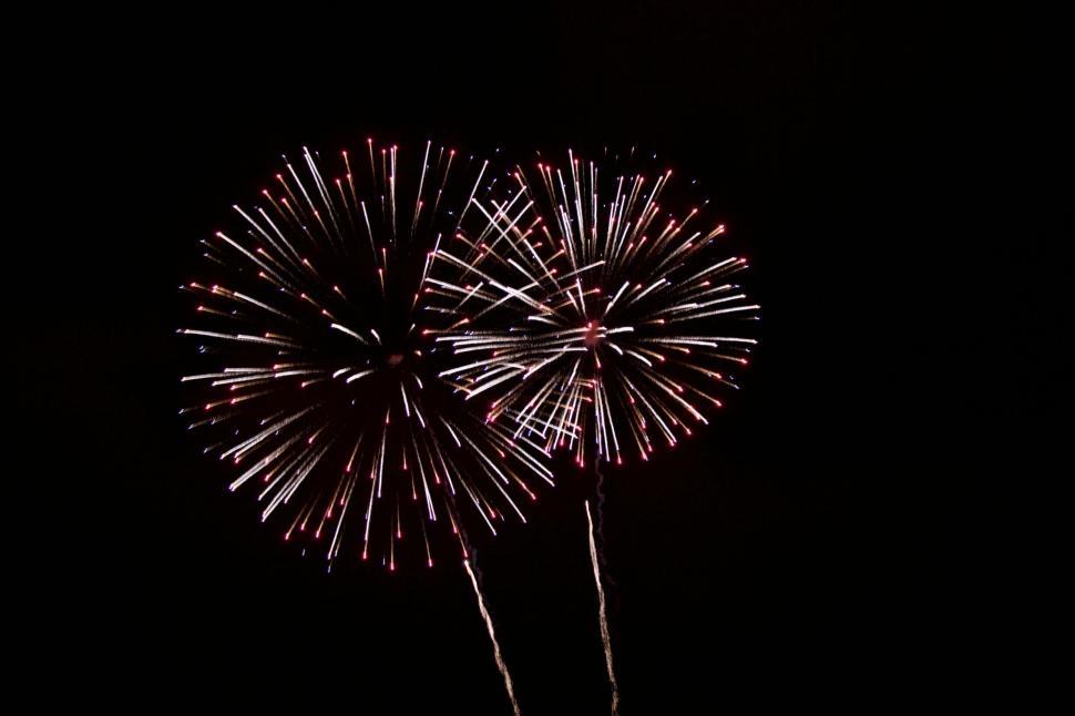 Free Image of Two colorful firework explosions against a dark sky. 