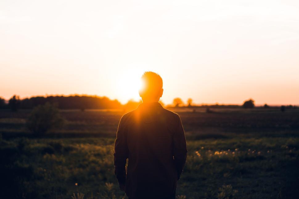 Free Image of Silhouette of a person standing against a sunset sky. 