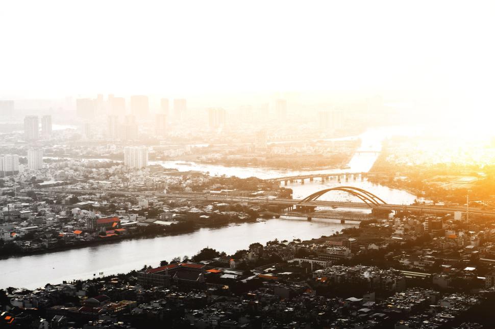 Free Image of Cityscape view at sunrise with river and bridges. 