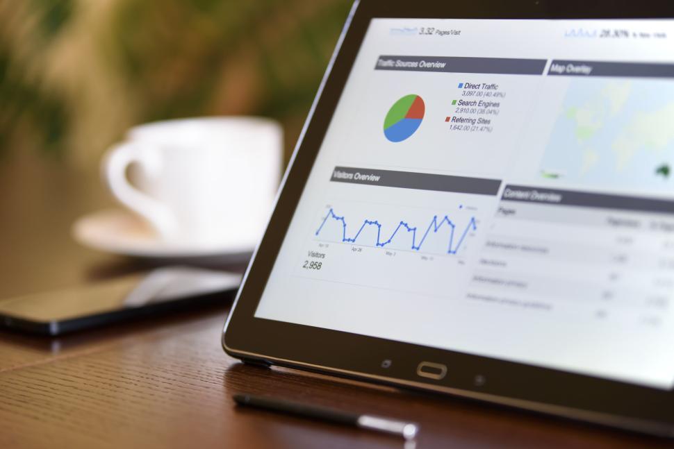 Free Image of Tablet displaying analytics data with coffee nearby. 
