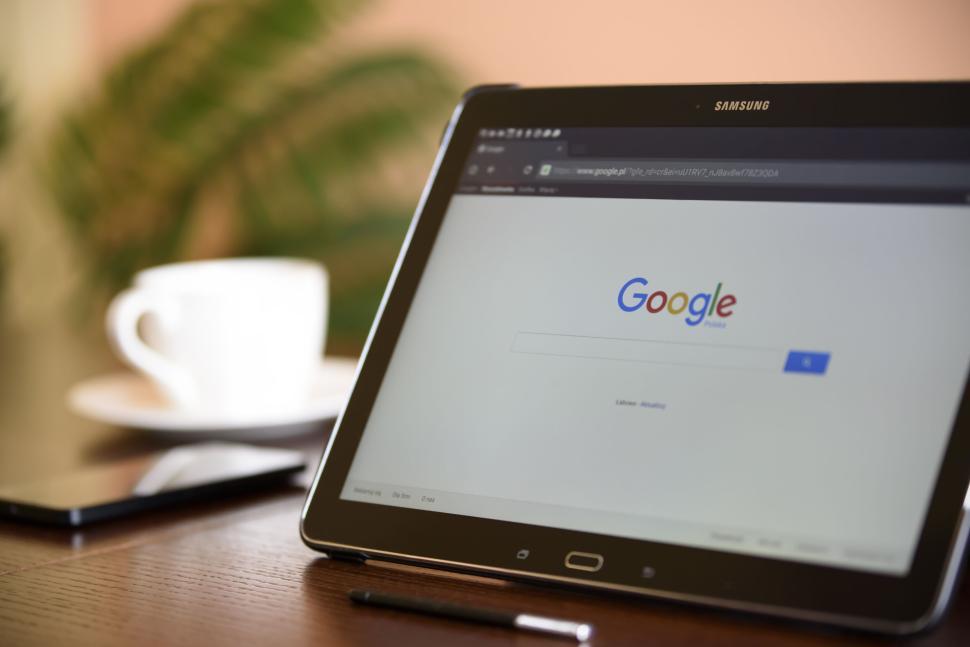 Free Image of Tablet with Google search on screen sitting beside coffee cup. 