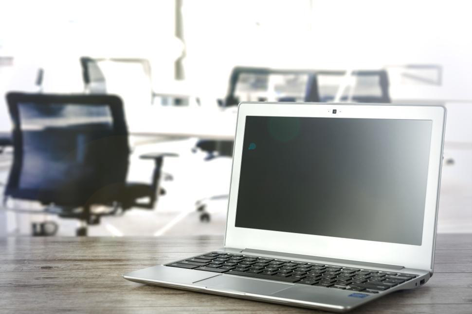 Free Image of Laptop on a wooden desk in a modern office workspace. 