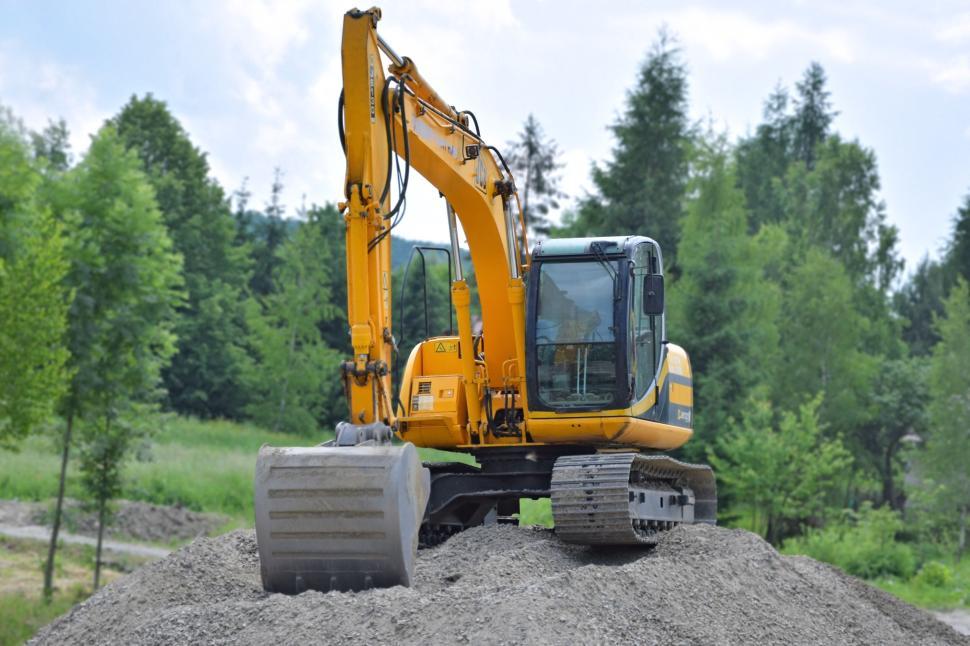 Free Image of Yellow excavator on construction site with green background 