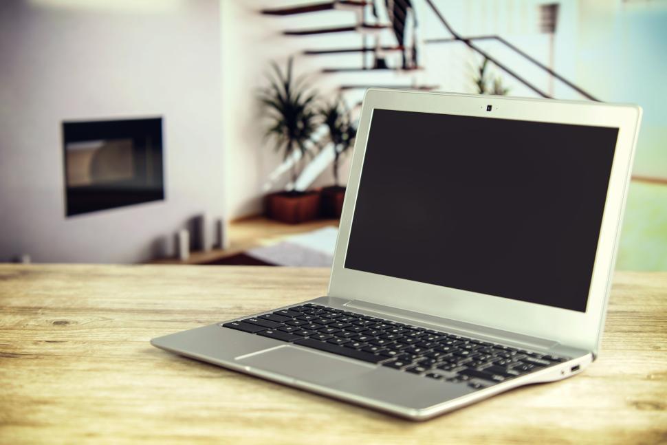 Free Image of Silver laptop on wooden table in modern living room. 