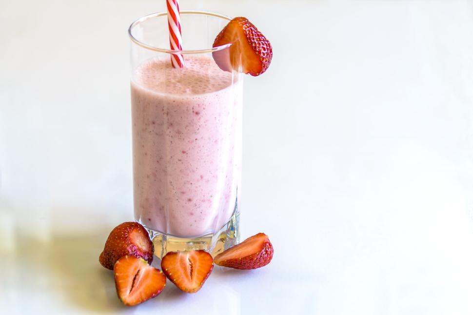 Free Image of Refreshing strawberry milkshake with straw and fresh strawberries. 