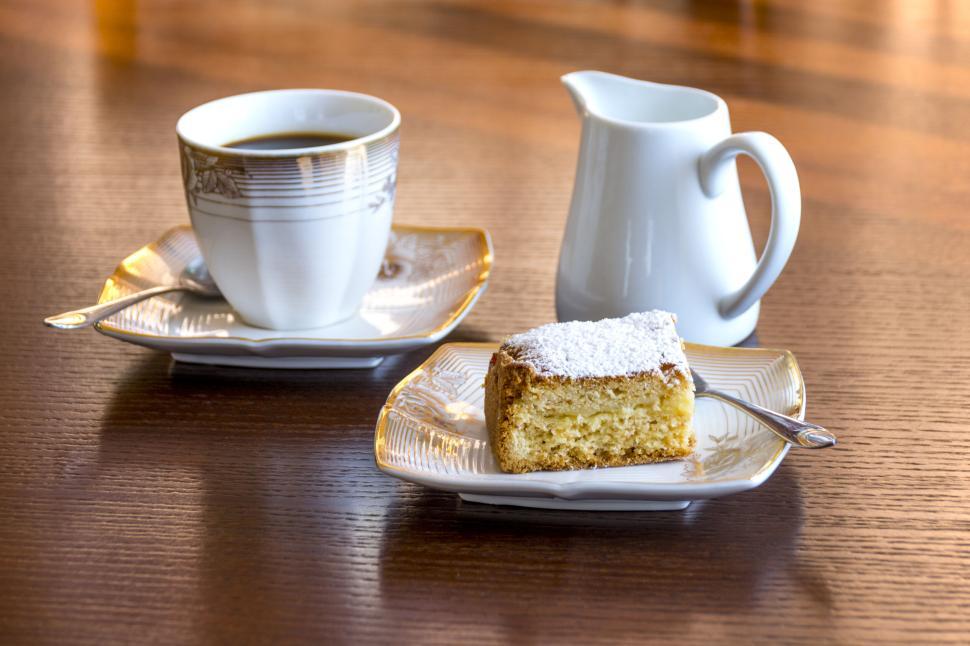 Free Image of Elegant morning tea setup with cake slice and white pitcher. 