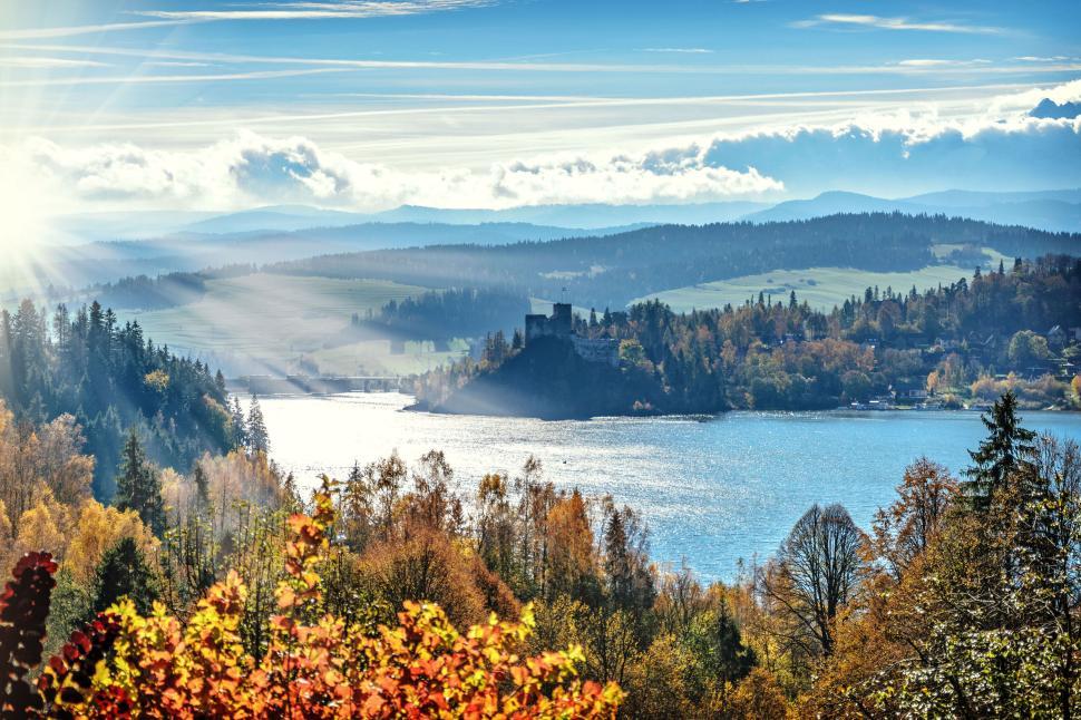 Free Image of Scenic view of lake, hills, and castle during autumn day. 