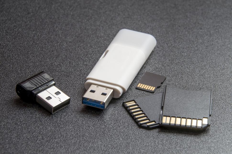 Free Image of Mix of USB drives and SD cards on black surface 