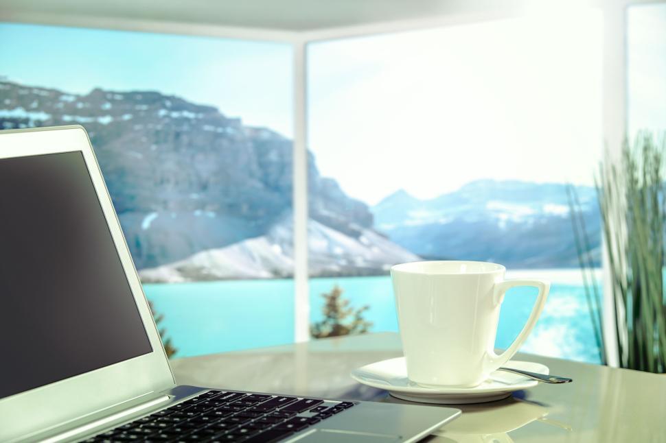 Free Image of Laptop and coffee cup with serene mountain view 