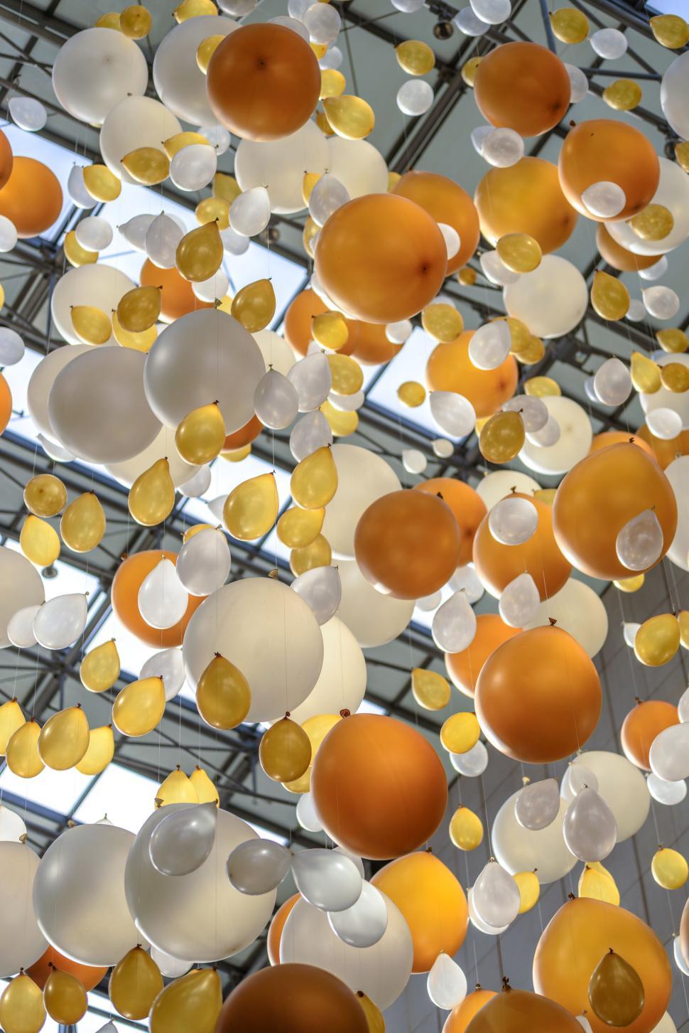 Free Image of Floating yellow and white balloons as decor 
