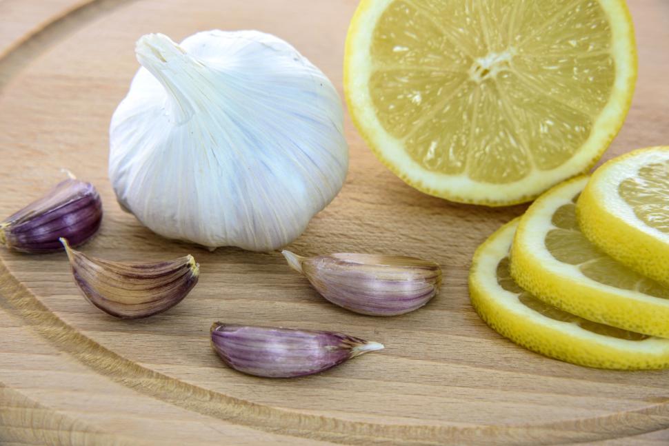 Free Image of Fresh garlic and lemon slices on wooden board 