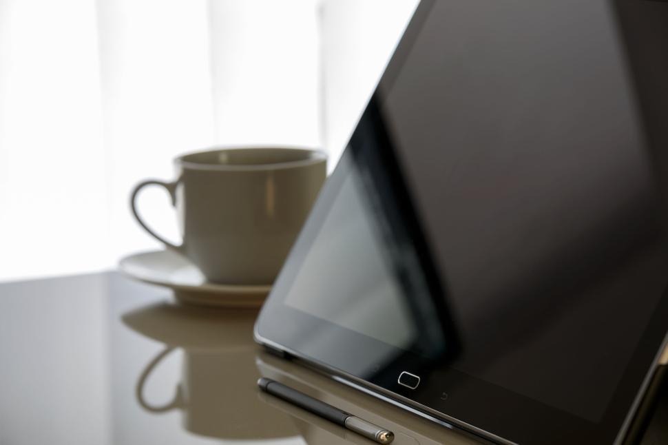 Free Image of Tablet and coffee cup on a desk with a pen 