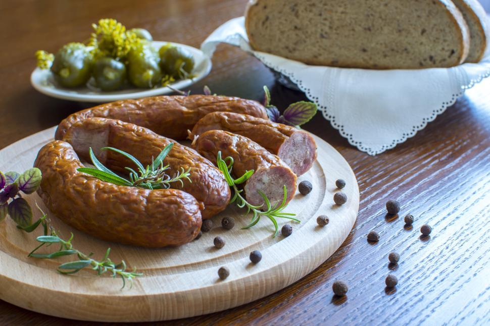 Free Image of Rustic sausages with herbs on a wooden table setting 