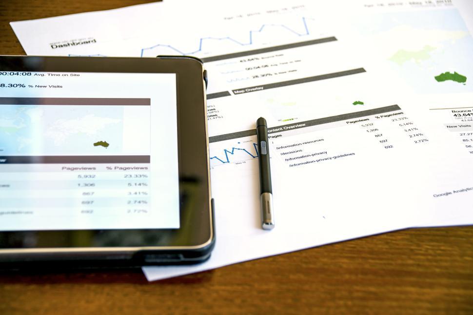 Free Image of Tablet and printed reports on a wooden office desk 