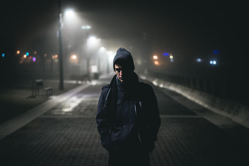 Free Image of Person wearing a beanie walking in foggy night. 