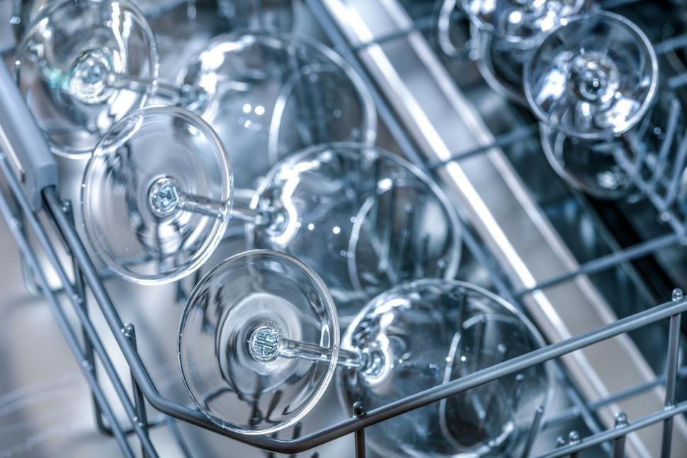 Free Image of Wine glasses placed upside down in an open dishwasher 