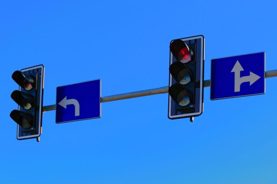 Free Image of Traffic lights and street signs on a clear blue sky day 