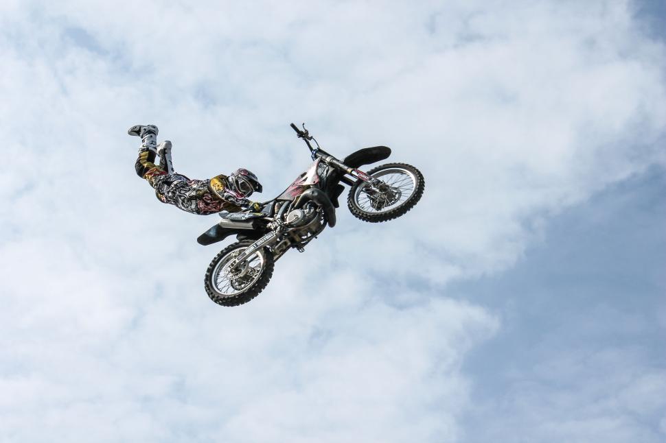 Free Image of Freestyle motocross rider in mid-air doing stunts. 