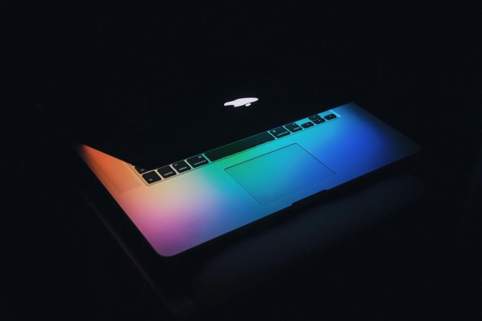 Free Image of Colorful reflections on a partially opened MacBook 