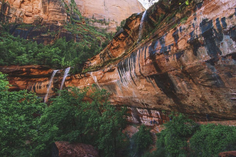 Free Image of Majestic view of a rocky cliff waterfall and forest. 