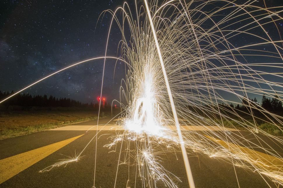 Free Image of Sparks flying on a dark road with starry night sky 