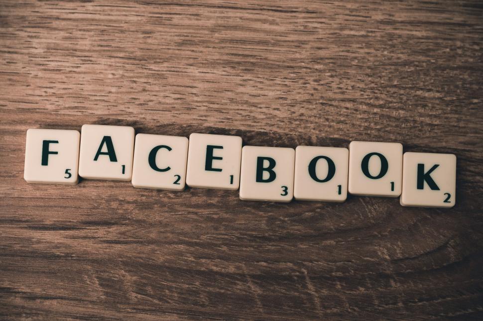 Free Image of Scrabble tiles spelling out Facebook on wooden surface. 