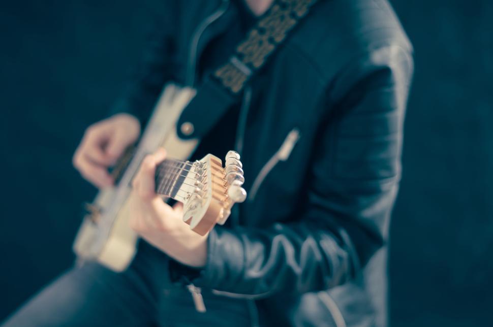 Free Image of Person playing electric guitar with focused hands shown. 