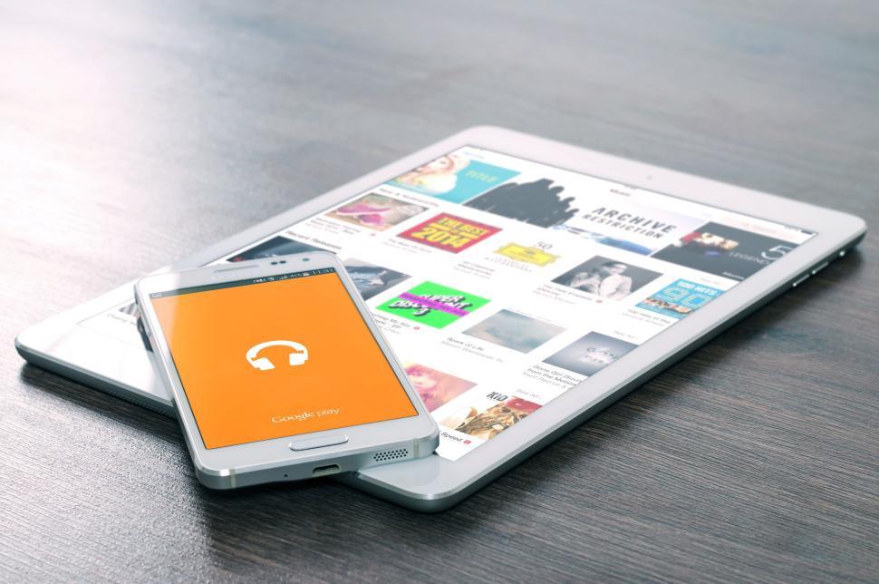 Free Image of Tablet with music app visible and smartphone on screen. 
