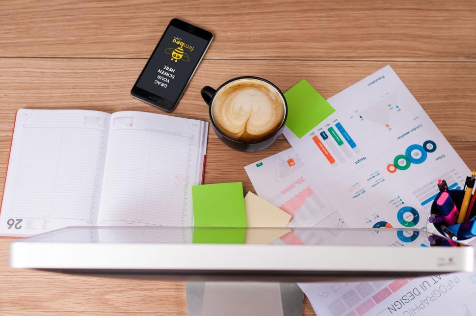 Free Image of Coffee cup, smartphone, documents, and open planner. 
