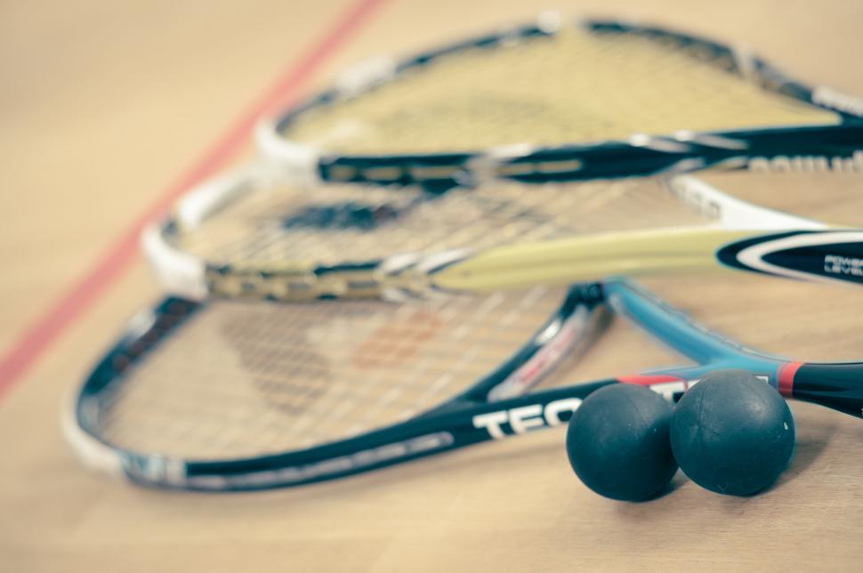 Free Image of Close-up of squash or badminton rackets with balls on court. 