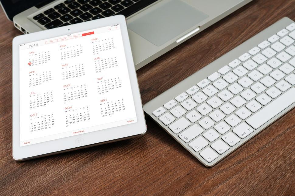 Free Image of Apple iPad displaying a calendar near a keyboard 