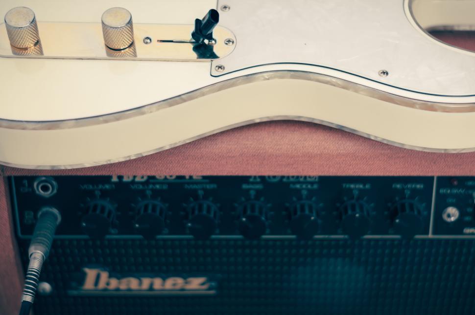 Free Image of Ibanez electric guitar rested on an amplifier ready for use. 