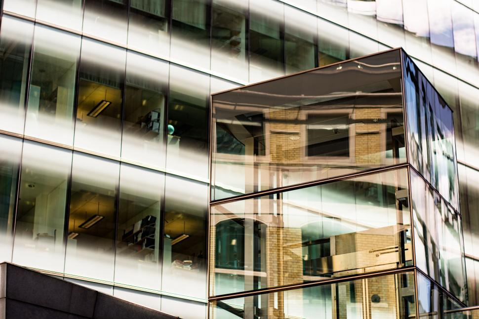 Free Image of Modern glass building with reflections of surroundings. 