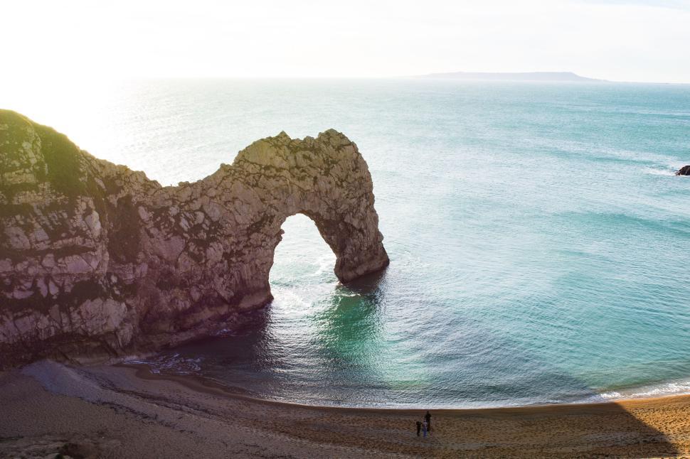 Free Image of Durdle Door arch rock formation over turquoise sea waters. 