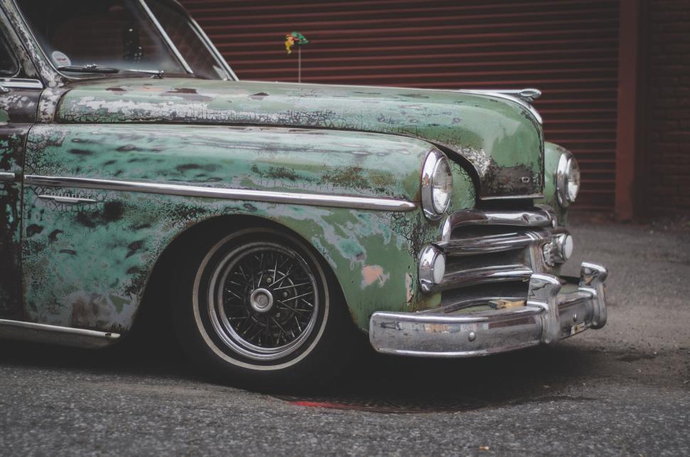 Free Image of Vintage car with rusted green paint on urban street 