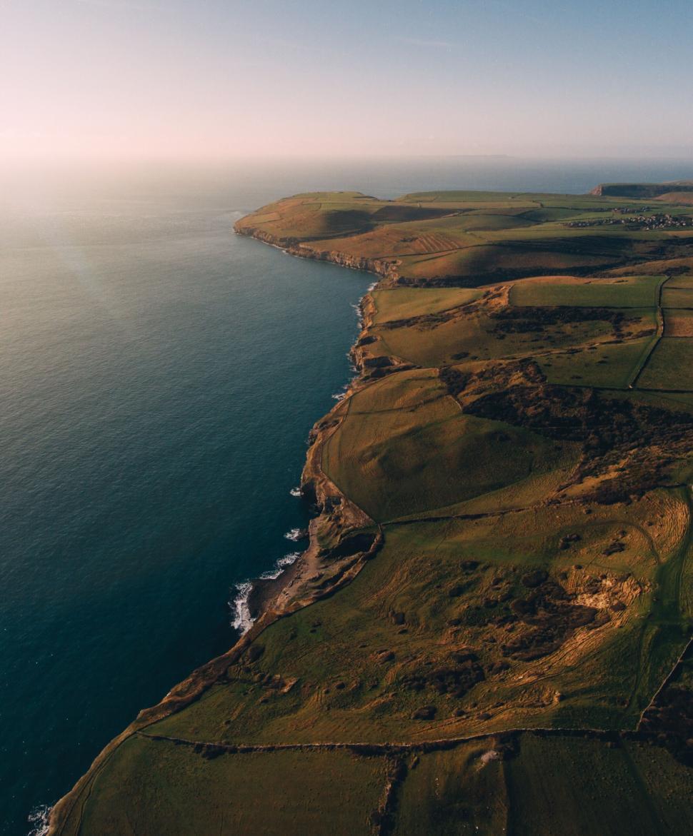 Free Image of Aerial view of coastal cliffs and vast ocean horizon. 