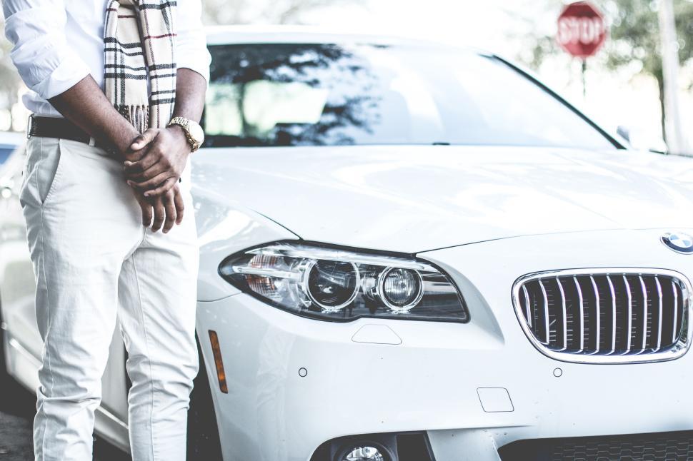 Free Image of Stylish person in white leaning against white BMW car 