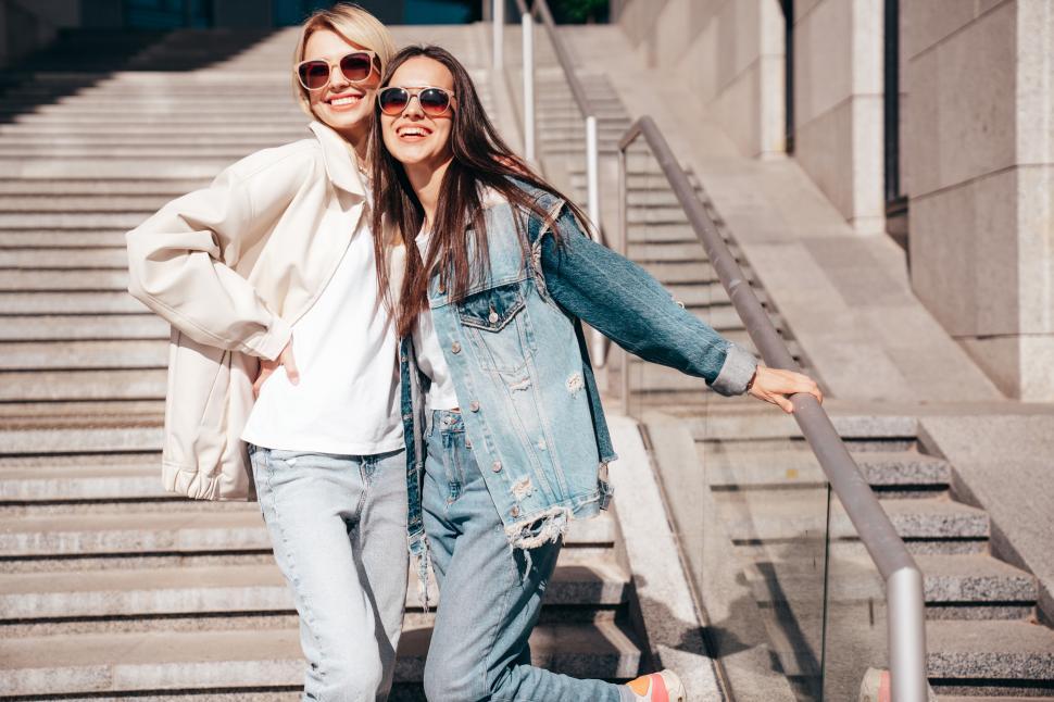Free Image of Two stylish women standing together on stairs of a building 