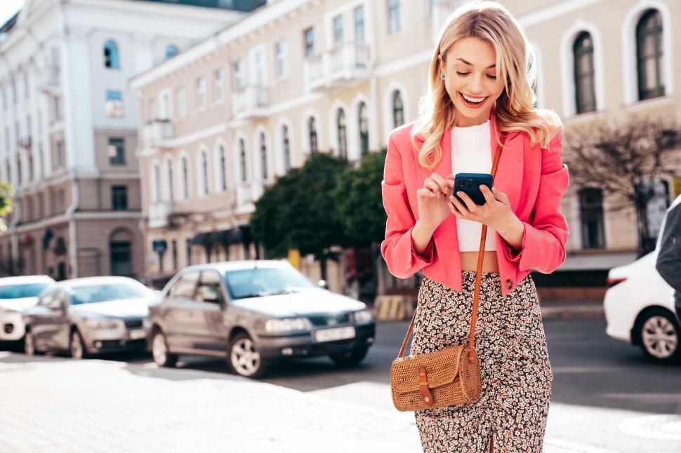 Free Image of Young woman in the city, looking at her phone 